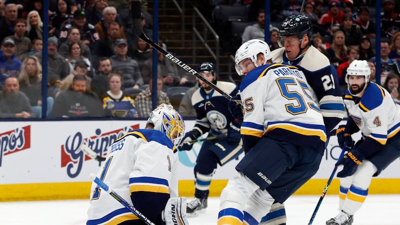 St. Louis Blues goalie Thomas Greiss, left, makes a stop in front of Columbus Blue Jackets...