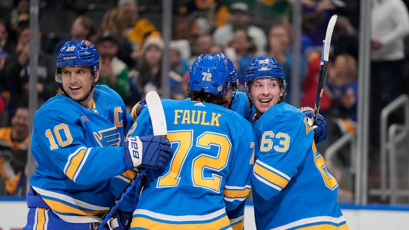 St. Louis Blues' Jake Neighbours (63) is congratulated by teammates Brayden Schenn (10) and...