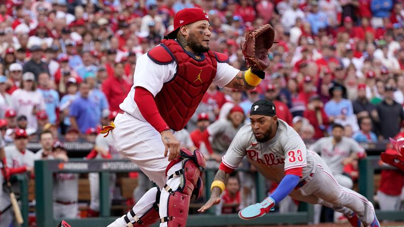 Philadelphia Phillies' Edmundo Sosa (33) scores past St. Louis Cardinals catcher Yadier Molina...