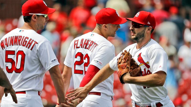 St. Louis Cardinals' Paul DeJong, right, celebrates with teammates Adam Wainwright (50) and...