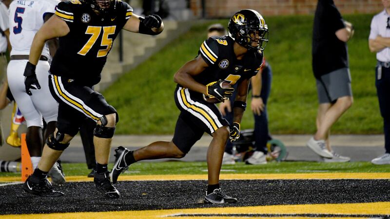Missouri wide receiver Luther Burden III scores as teammate Mitchell Walters (75) watches...