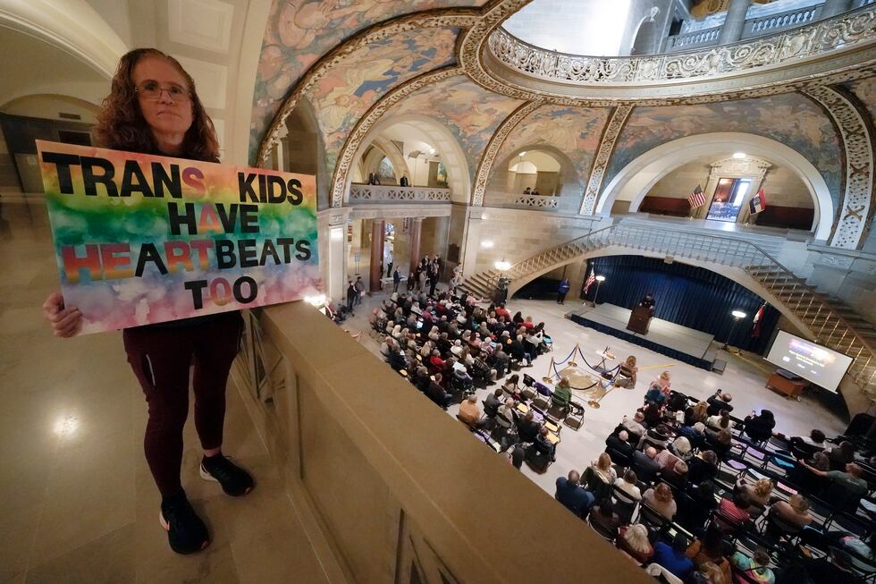 Julia Williams holds a sign in counterprotest during a rally in favor of a ban on...