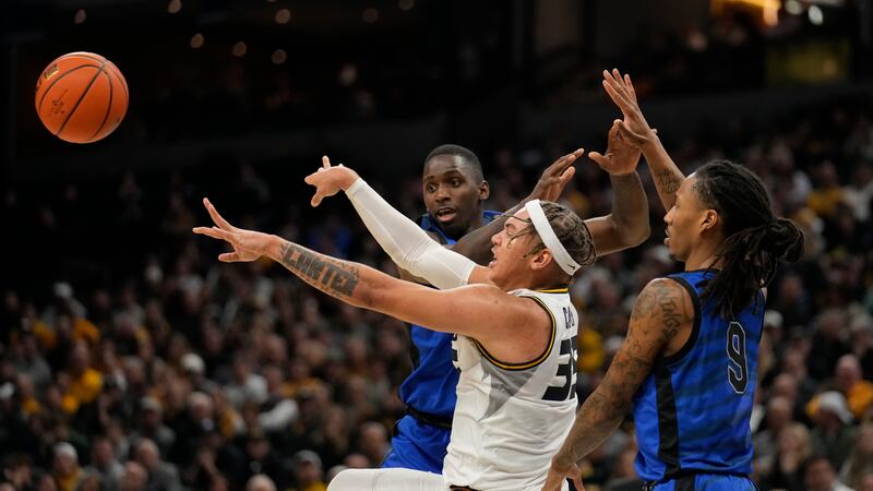 Missouri's Noah Carter, center, passes as Memphis' David Jones, left, and Caleb Mills (9)...