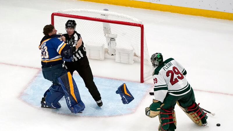 St. Louis Blues goaltender Jordan Binnington, left, is held back from fighting Minnesota Wild...