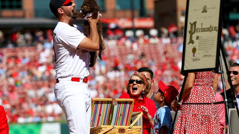 St. Louis Cardinals' Adam Wainwright is gifted a puppy as he is honored during his retirement...