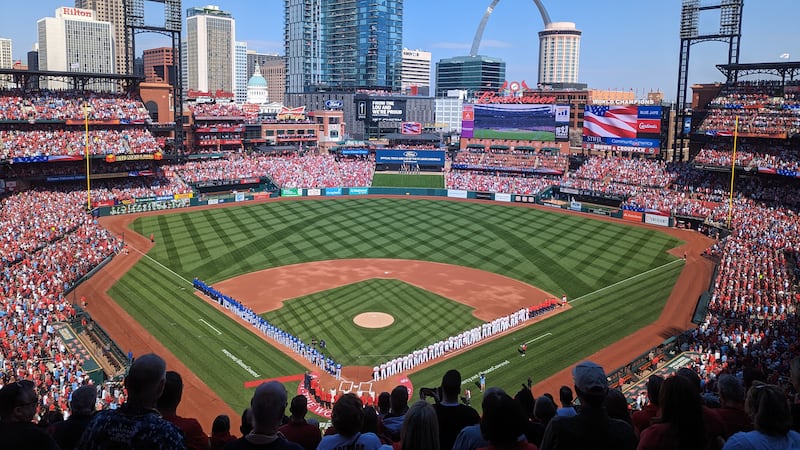 The St. Louis Cardinals and Toronto Blue Jays stand waiting for the national anthem, which was...