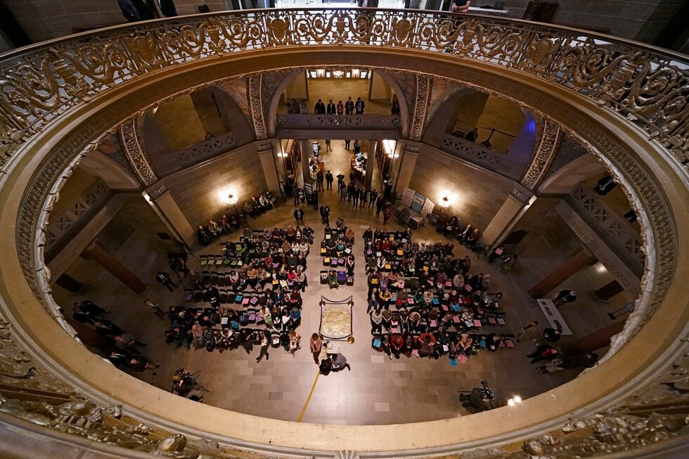 People listen to a speaker during a rally in favor of a ban on gender-affirming health care...