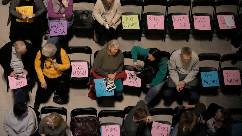 People wait for the start of a rally in favor of legislation banning gender-affirming...