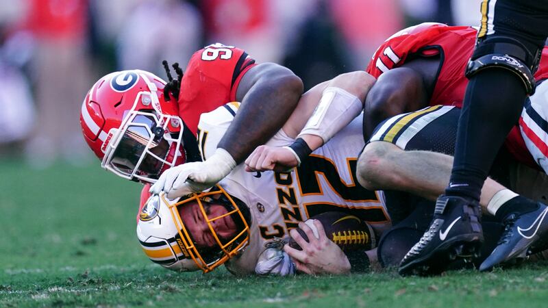 Missouri quarterback Brady Cook (12) is sacked by Georgia defensive lineman Zion Logue (96)...