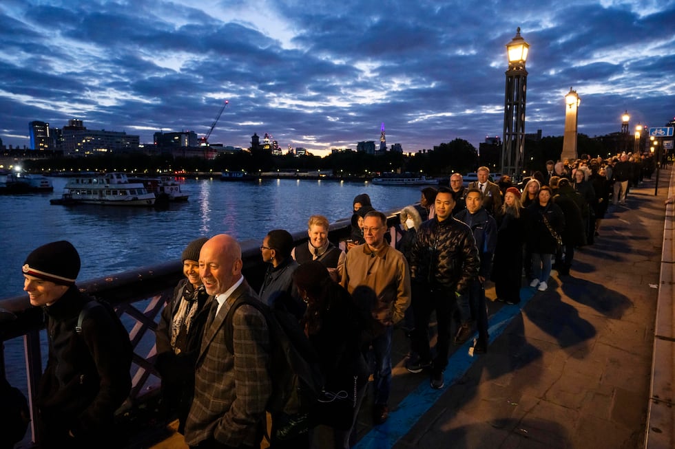 People stand in a queue to pay their respects to the late Queen Elizabeth II during the...