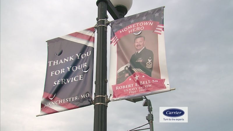 Along a busy stretch of Manchester Road near Highway 141, hangs 24 banners, each telling the...