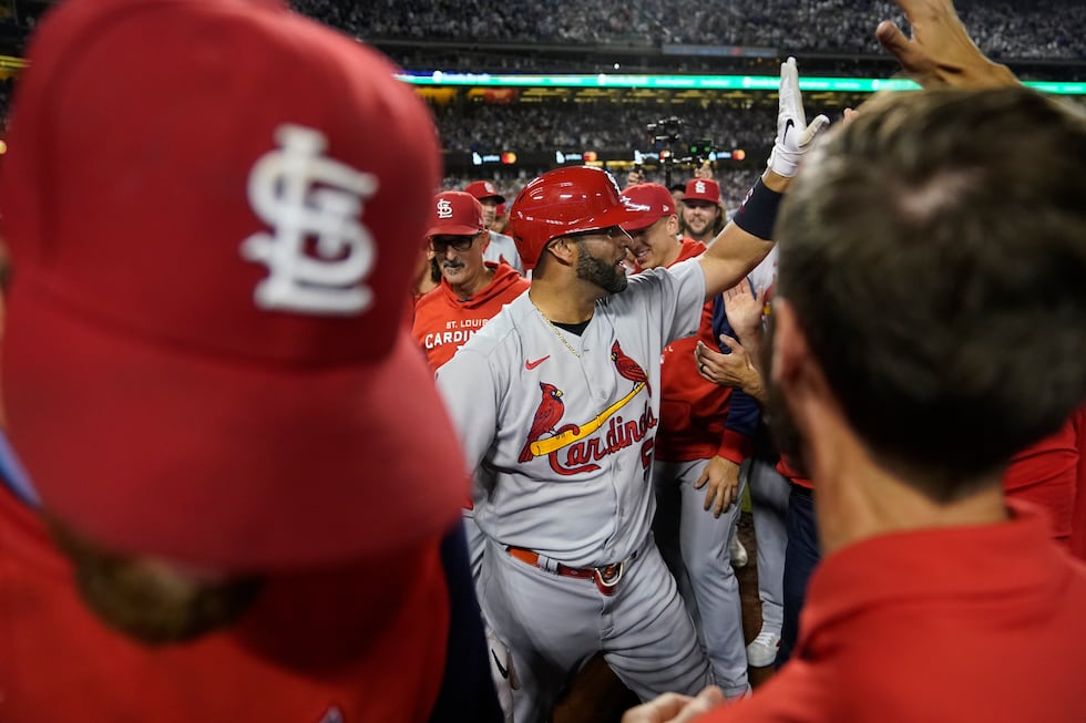 St. Louis Cardinals designated hitter Albert Pujols, center, celebrates with teammates after...